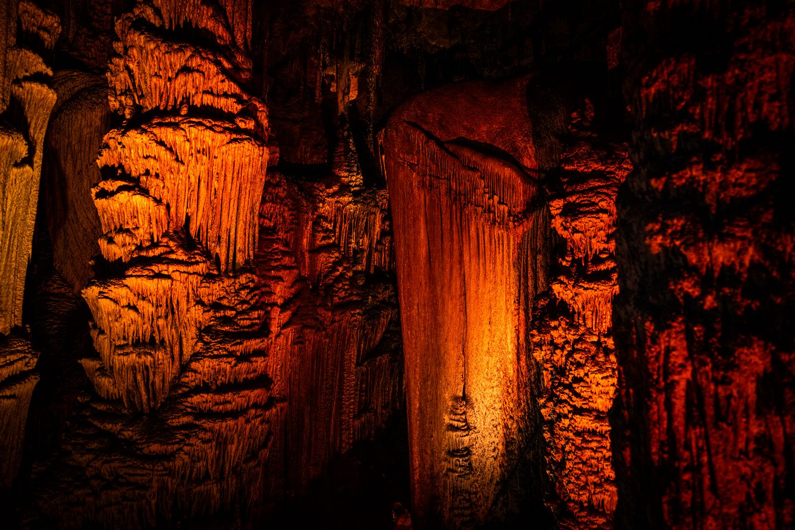 Tram winding through illuminated stalactite formations inside Harrison's Cave