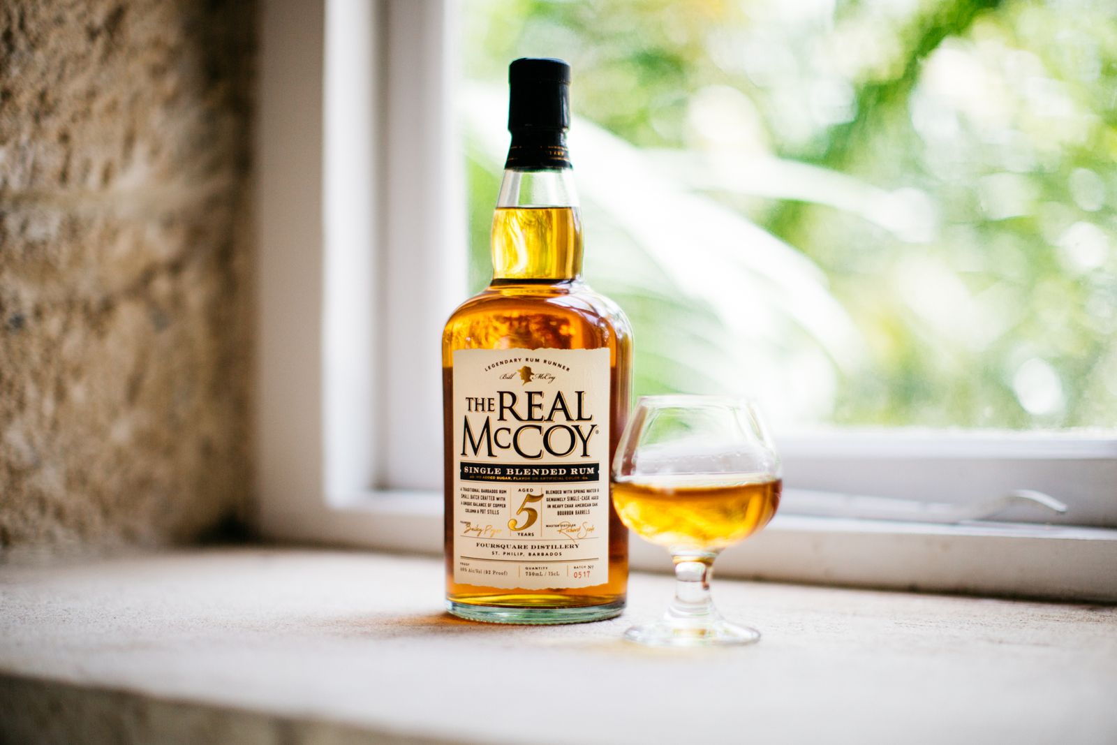 Couple tasting aged rum at a wooden bar inside a historic Barbados distillery