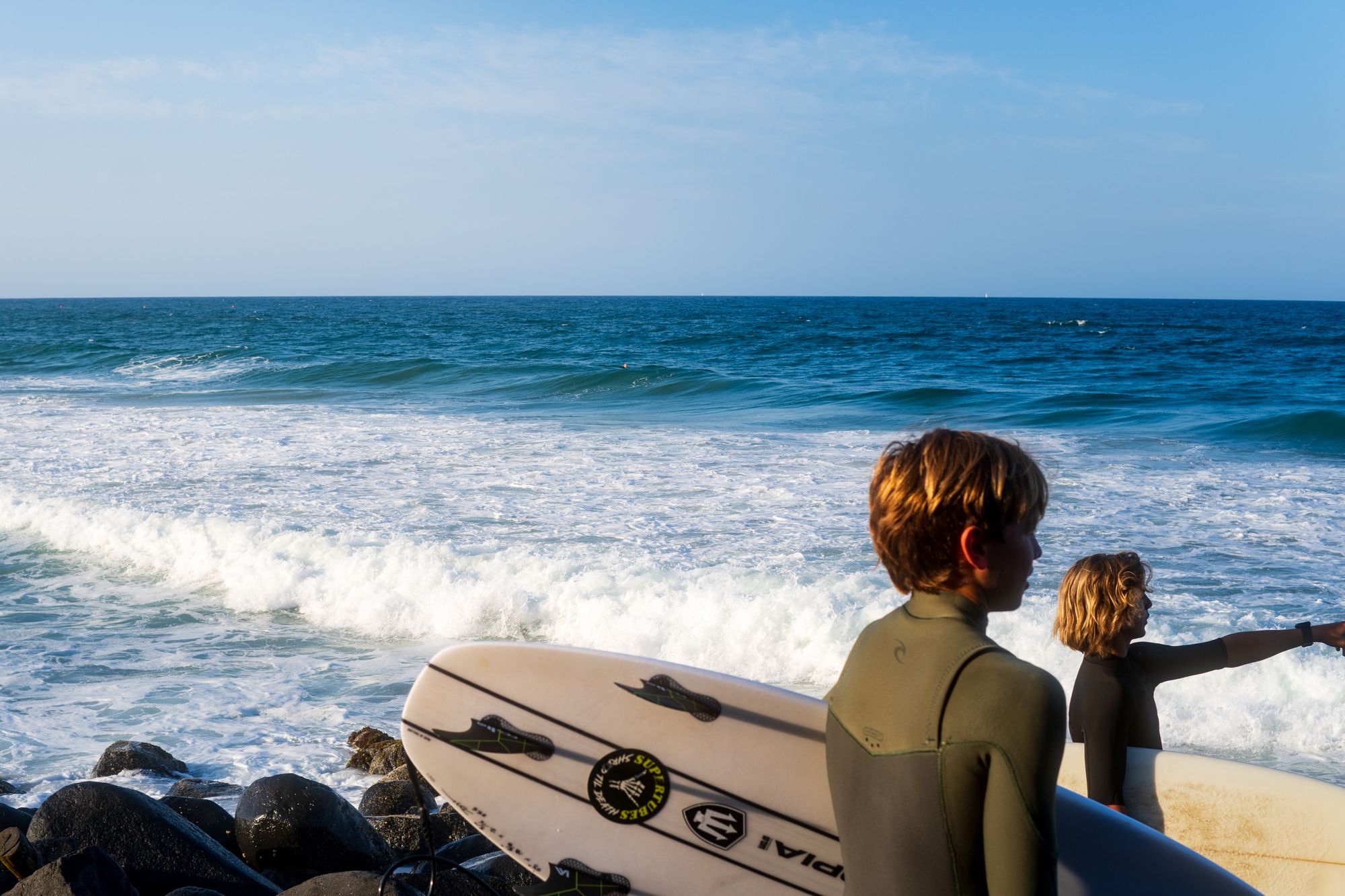 Young surfers preparing to hit the waves on sunny beach