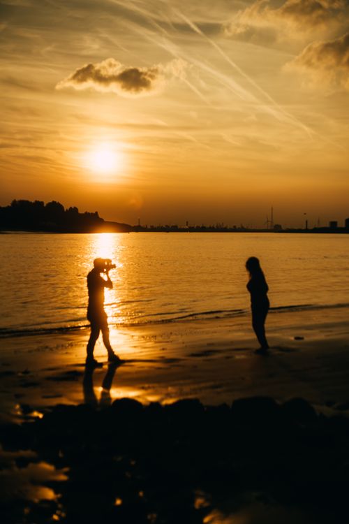 Photographer capturing a sunset portrait on a tropical beach