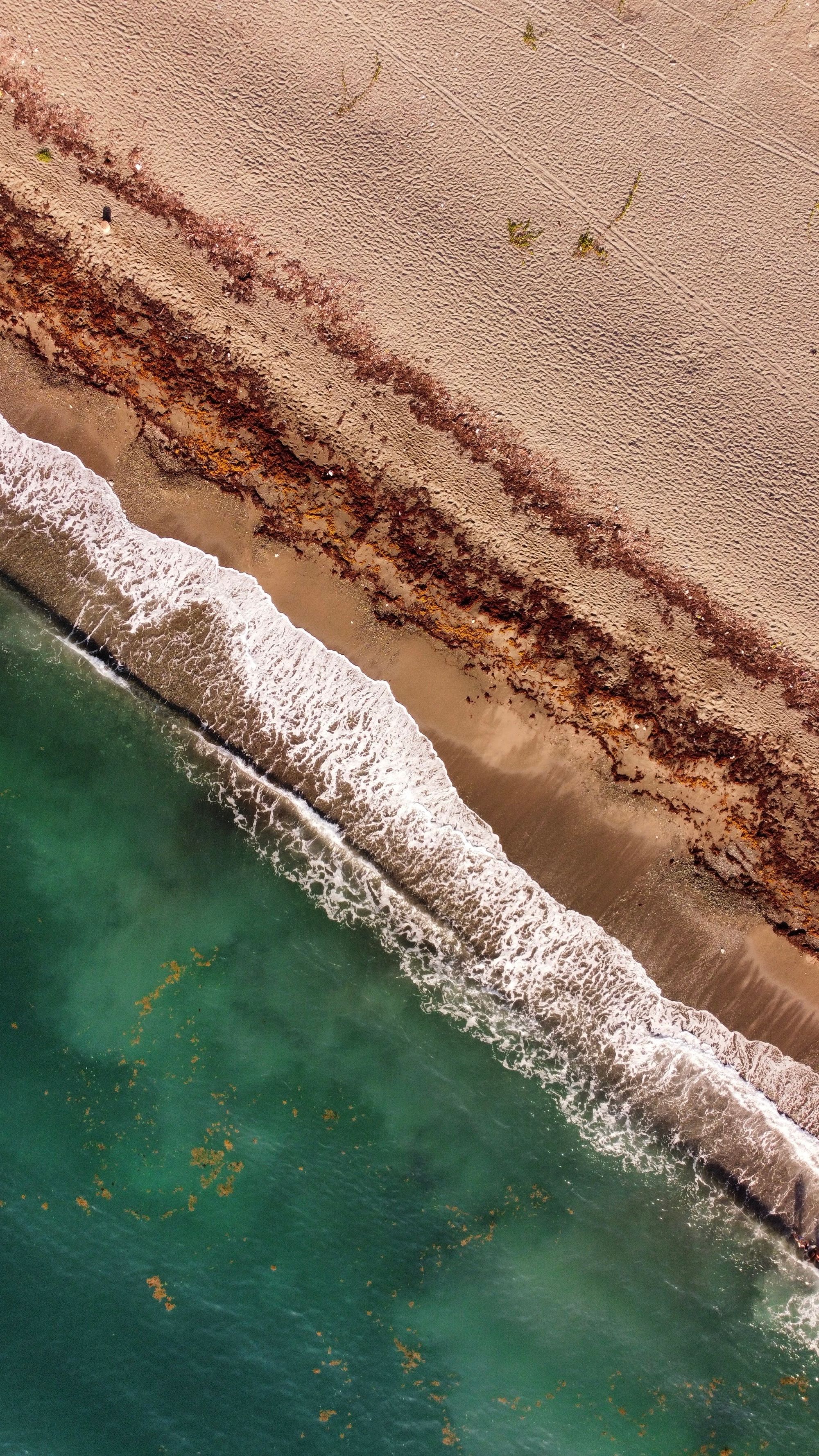 Aerial view of Jamaican beach with turquoise waves and white sand
