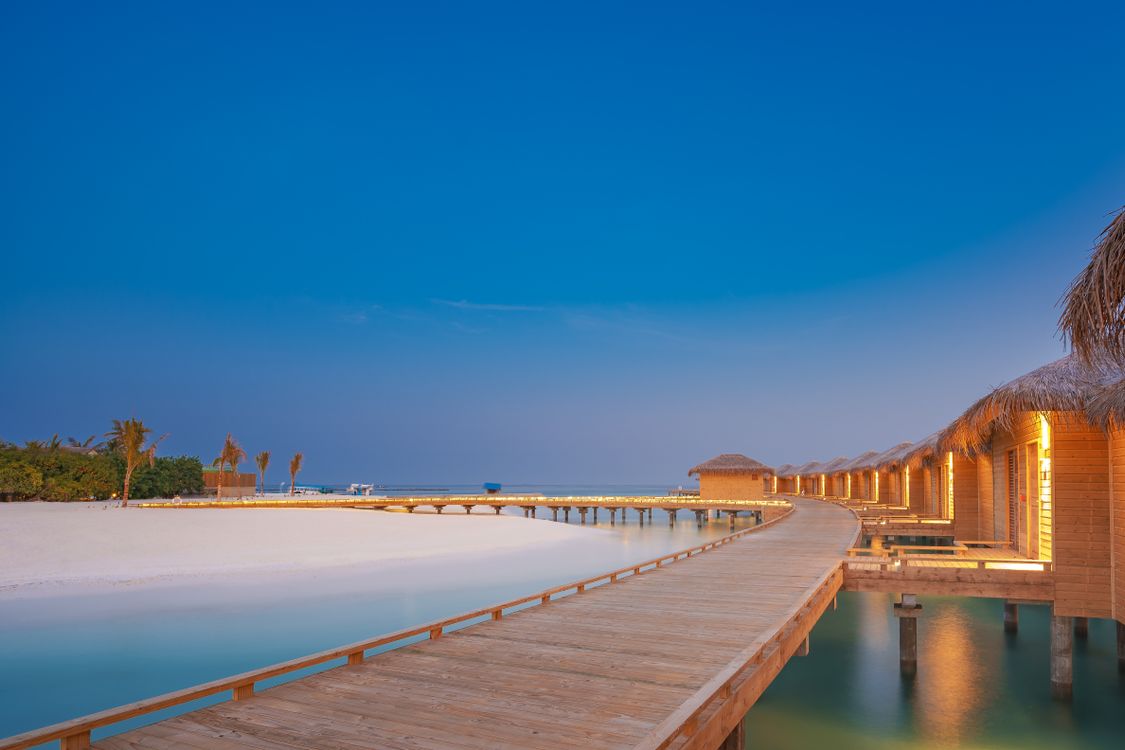 Serene overwater bungalows on turquoise lagoon under blue sky