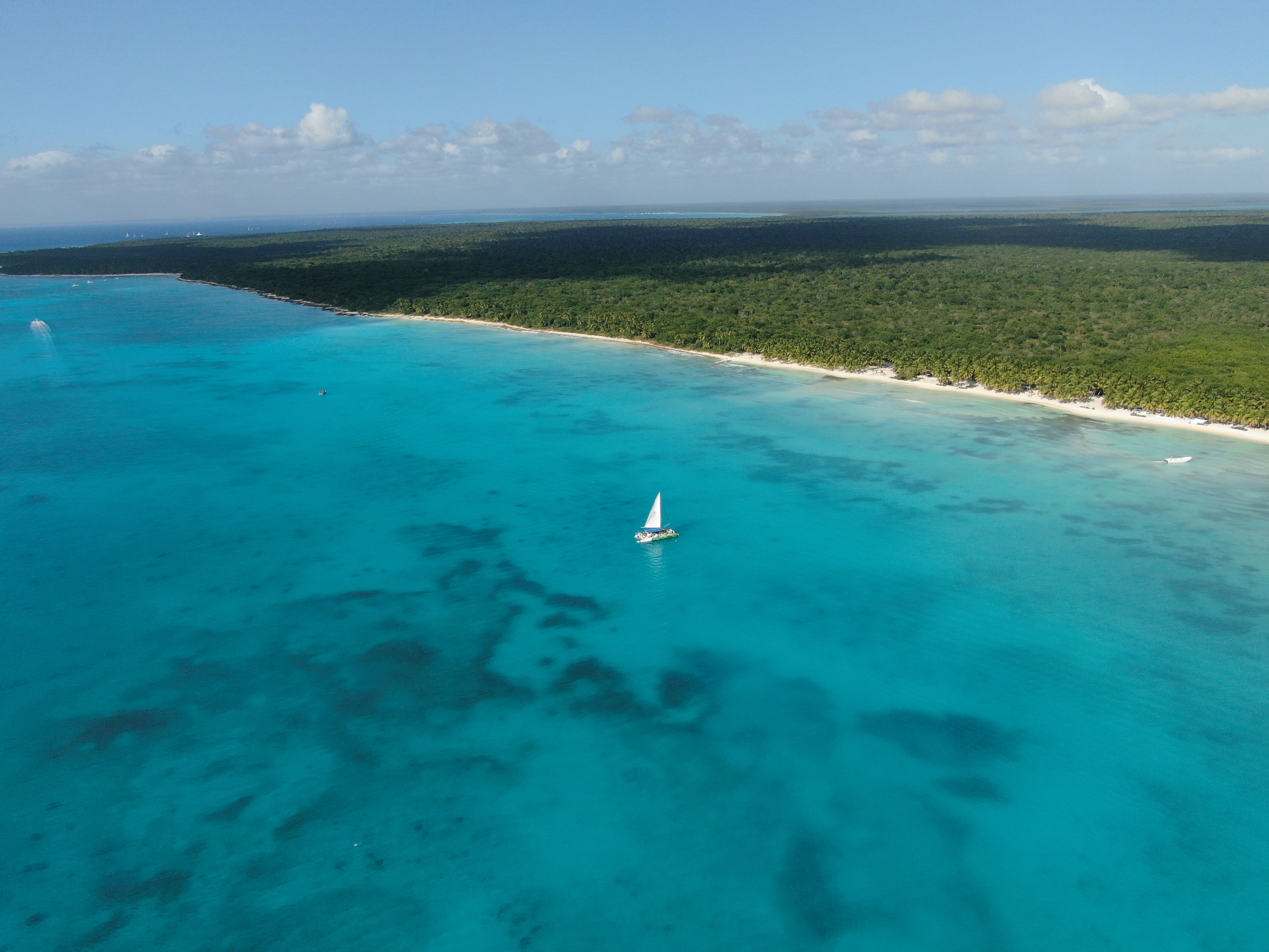 Aerial view of sailboats in clear Caribbean waters.
