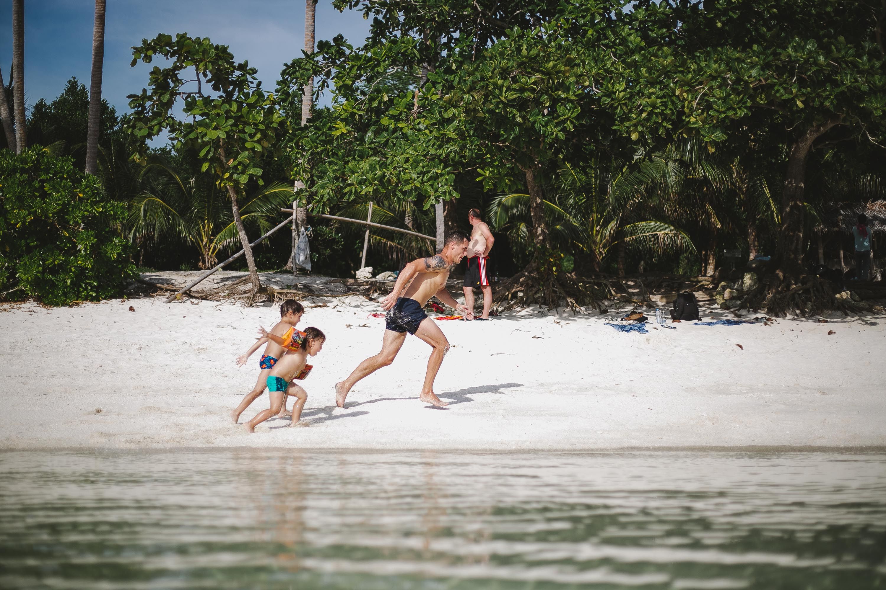 A father playing with children on a Caribbean beach