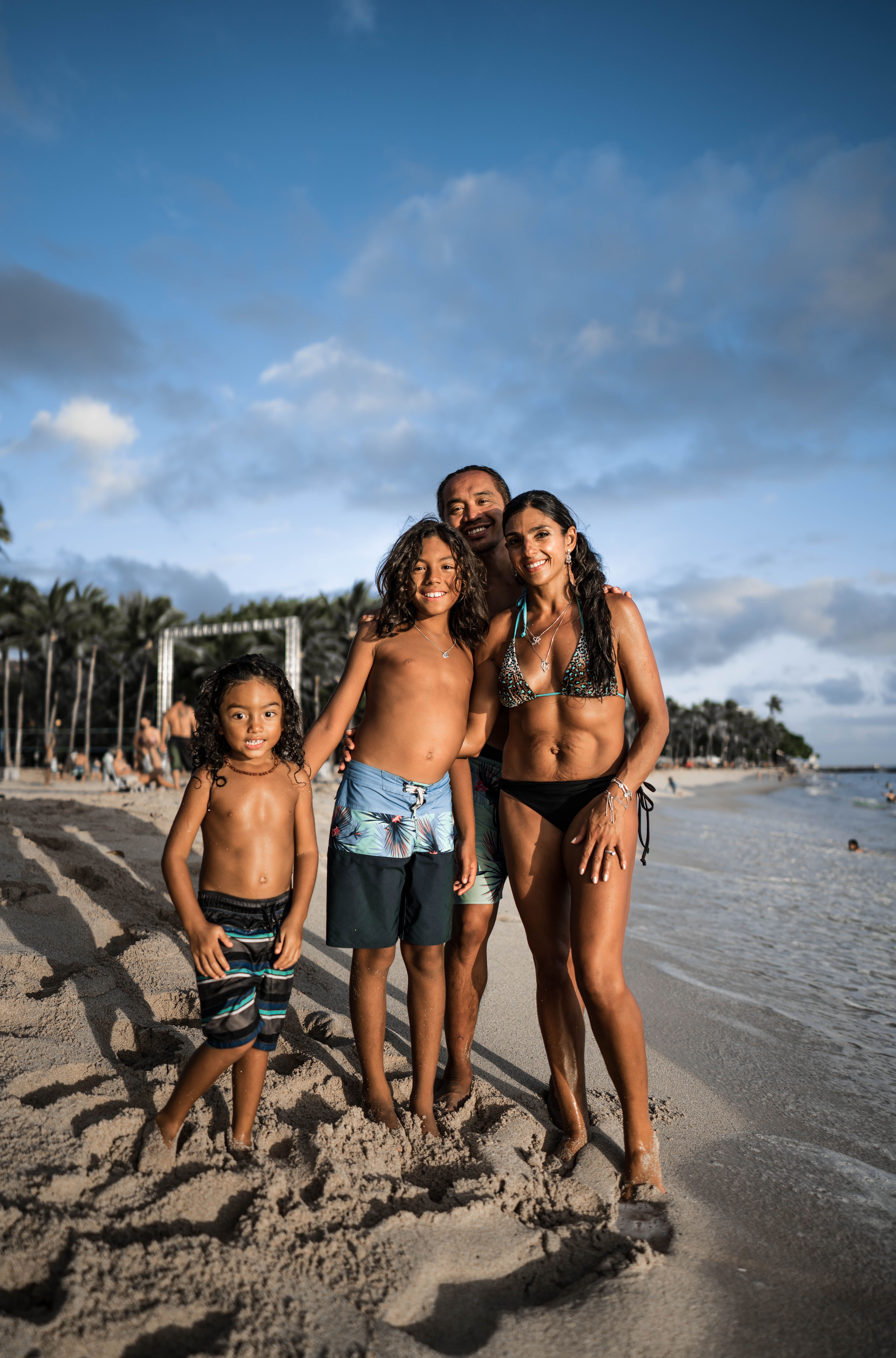Family walking hand in hand on a sunny Mexican beach with turquoise water and white sand