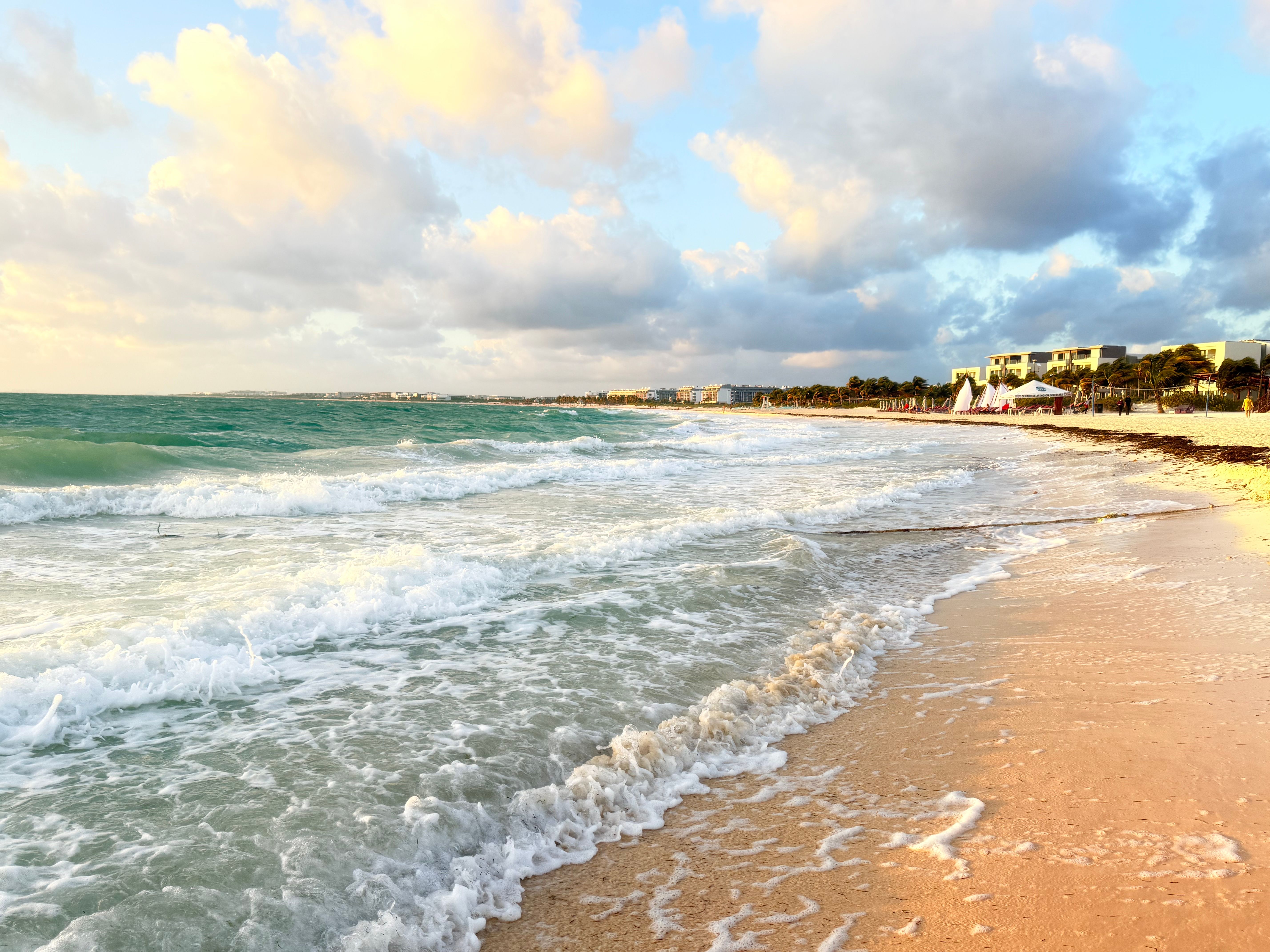 Sunrise over a calm Caribbean beach with golden light
