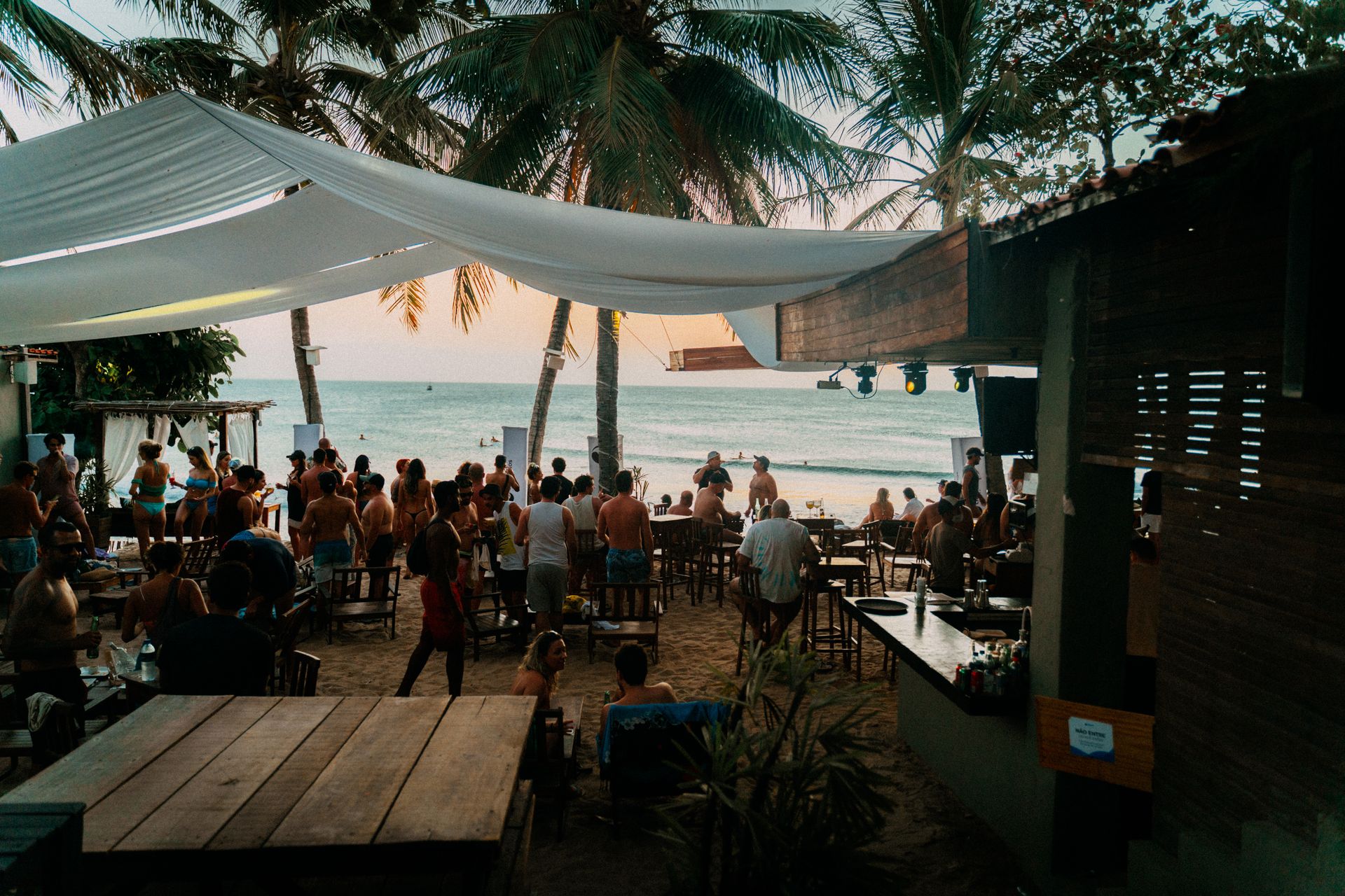 Seaside bar customers at patio during sunset